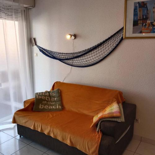 - un canapé dans une chambre avec un hamac sur le mur dans l'établissement Studio cabine équipée pour 4 personnes 4CALYI/2, à Canet