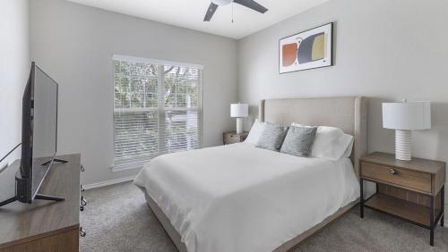 Habitación blanca con cama y TV en Landing Modern Apartment with Amazing Amenities (ID3078X18), en Dallas