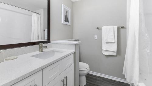 Baño blanco con lavabo y aseo en Landing Modern Apartment with Amazing Amenities (ID3078X18), en Dallas