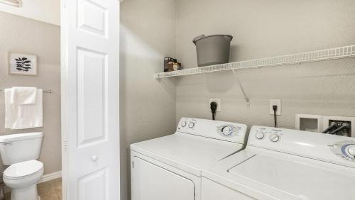 プランテーションにあるLanding Modern Apartment with Amazing Amenities (ID5223)の白いバスルーム(洗濯機、トイレ付)