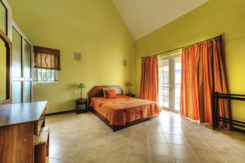 a bedroom with a bed and a large window at Pereybere Beach Villas in Pereybere