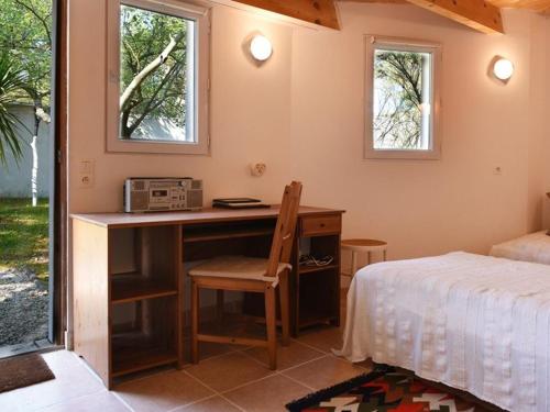 a bedroom with a desk and a bed and a bed and window at Maison Les Portes-en-Ré, 3 pièces, 6 personnes - FR-1-434-18 in Les Portes