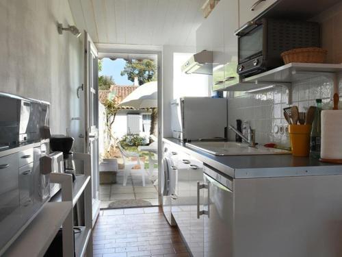 a large white kitchen with a view of a patio at Maison Les Portes-en-Ré, 3 pièces, 6 personnes - FR-1-434-18 in Les Portes