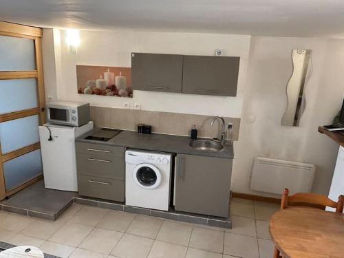 uma cozinha com um lavatório e uma máquina de lavar roupa em Studio Sanae em Lézignan-Corbières