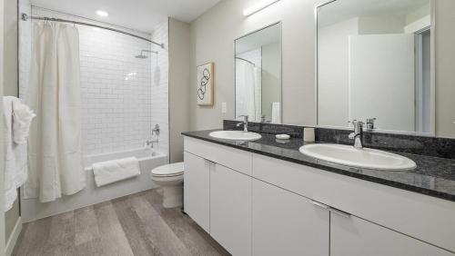 a white bathroom with two sinks and a toilet at Landing Modern Apartment with Amazing Amenities (ID1348X886) in Sandy