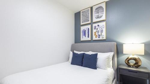een slaapkamer met een wit bed en blauwe muren bij Landing Modern Apartment with Amazing Amenities (ID5061X74) in Portland