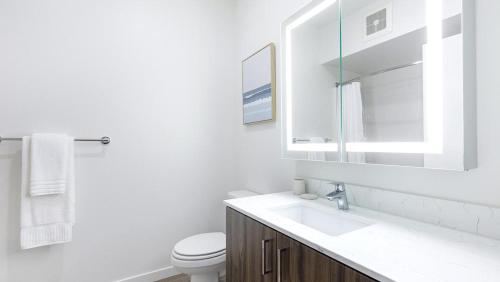 een witte badkamer met een wastafel en een toilet bij Landing Modern Apartment with Amazing Amenities (ID5061X74) in Portland
