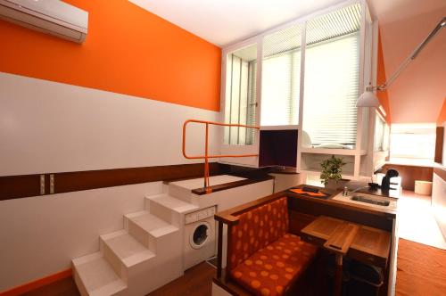 Dieses orangefarbene und weiße Zimmer verfügt über eine Treppe mit einer Bank. in der Unterkunft The Serra Vision in Ivrea