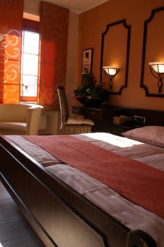 a bedroom with a bed and a desk and a mirror at Le Pavillon in Echternach