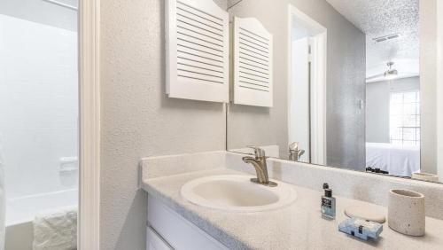 a white bathroom with a sink and a mirror at Landing Modern Apartment with Amazing Amenities (ID8521X55) in Fort Worth