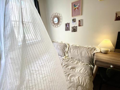 a curtain hanging over a couch next to a table at Morning room RED PANDA GUESTHOUSE in Seoul