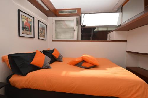 ein großes orangenes Bett in einem kleinen Zimmer in der Unterkunft The Serra Vision in Ivrea