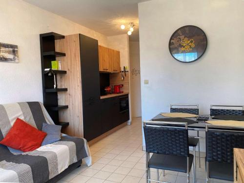 Il dispose d'une cuisine et d'un salon avec un canapé et une table. dans l'établissement Appartement T1 avec terrasse, tout équipé, proche commodités à Balaruc-les-Bains - FR-1-553-239, à Balaruc-les-Bains