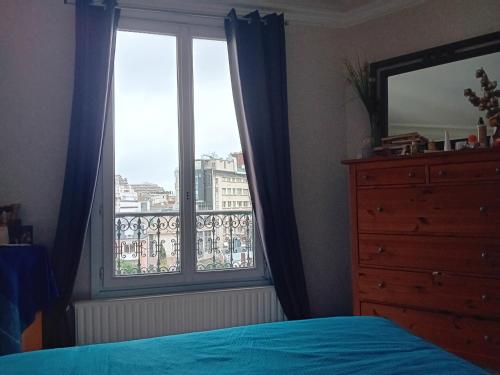une chambre avec un lit, une commode et une fenêtre dans l'établissement Appartement 50 m2 Centre Boulogne Metro en bas, tous commerces, à Boulogne-Billancourt