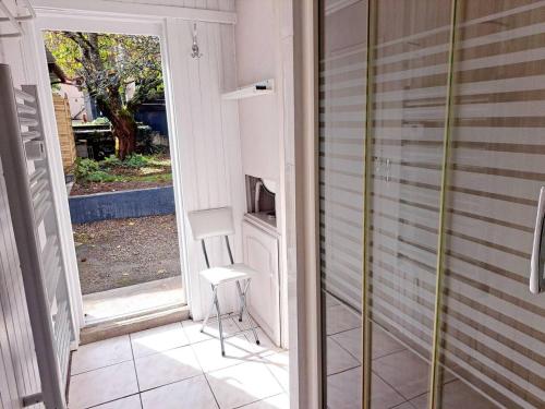 szklanymi drzwiami prowadzącymi na patio z krzesłem w obiekcie Maison d'une chambre avec terrasse a Tarascon sur Ariege w mieście Tarascon-sur-Ariège