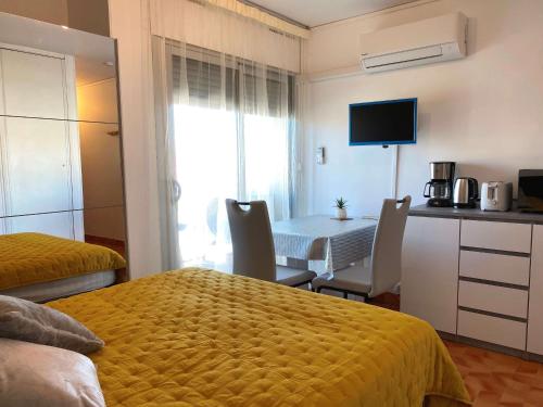 Il comprend une chambre avec une table et une cuisine avec une salle à manger. dans l'établissement Coquet Studio Climatisé avec Balcon et Wi-Fi près du Parc à Balaruc-les-Bains - FR-1-553-242, à Balaruc-les-Bains