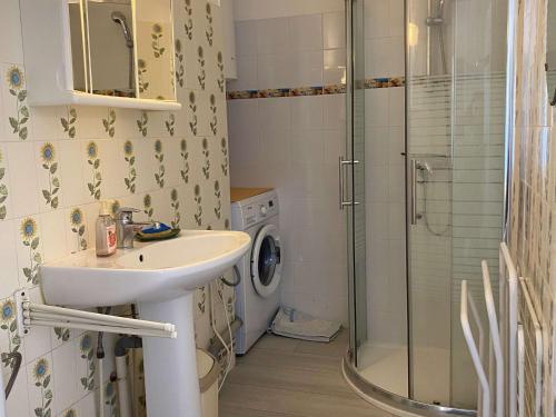une salle de bain avec un lavabo et une machine à laver dans l'établissement Coquet Studio Climatisé avec Balcon et Wi-Fi près du Parc à Balaruc-les-Bains - FR-1-553-242, à Balaruc-les-Bains