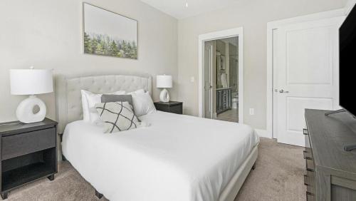 Habitación blanca con cama blanca y escritorio. en Landing Modern Apartment with Amazing Amenities (ID2268X42), en Raleigh