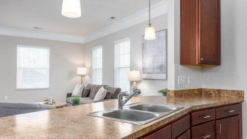 een keuken met een wastafel en een woonkamer bij Landing Modern Apartment with Amazing Amenities (ID7606X42) in Columbus