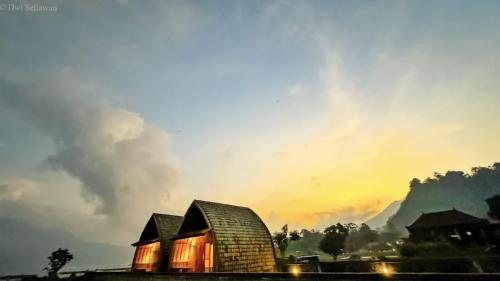 um celeiro com o sol brilhando sobre ele ao pôr-do-sol em Volcano Cabins em Kubupenlokan