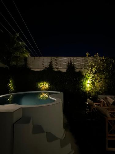 un patio trasero con piscina por la noche con luces en شاليه الماسيه خاص و مميز بأحدث المواصفات لنصنع الجمال بعينه, en Riad