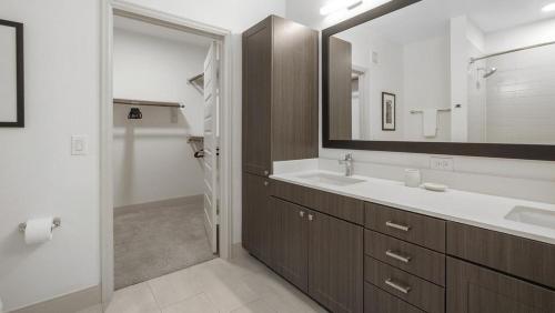 a bathroom with a sink and a large mirror at Landing Modern Apartment with Amazing Amenities (ID5473X56) in Humble