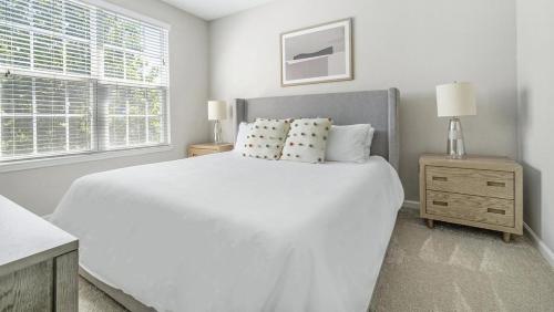 a white bedroom with a white bed and a window at Landing Modern Apartment with Amazing Amenities (ID1375X099) in Charlotte
