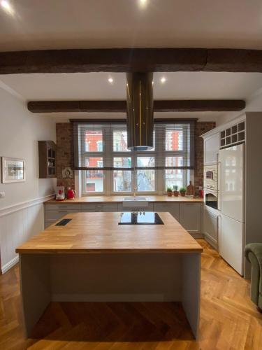 a kitchen with a large wooden island in the middle at Apartments PSD - Anny Łajming 1C in Słupsk