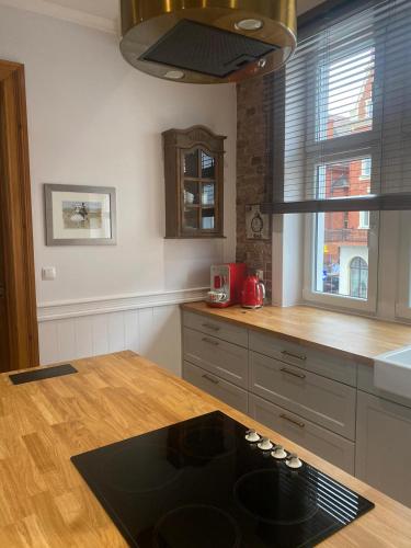 a kitchen with a wooden counter top and a sink at Apartments PSD - Anny Łajming 1C in Słupsk