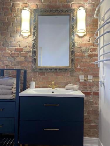 a bathroom with a sink and a brick wall at Apartments PSD - Anny Łajming 1C in Słupsk