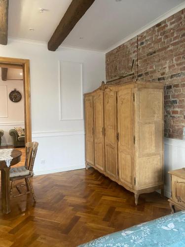 a room with a wooden cabinet and a brick wall at Apartments PSD - Anny Łajming 1C in Słupsk