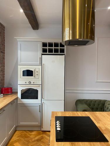 a kitchen with a white refrigerator and a microwave at Apartments PSD - Anny Łajming 1C in Słupsk