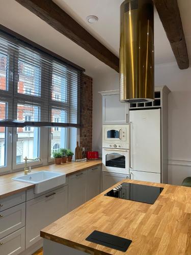 a kitchen with white appliances and a wooden counter top at Apartments PSD - Anny Łajming 1C in Słupsk