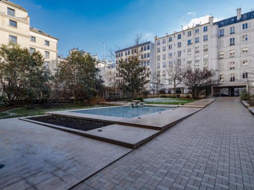 une cour avec piscine dans un immeuble dans l'établissement Eiffel Tower Loft residence, à Paris