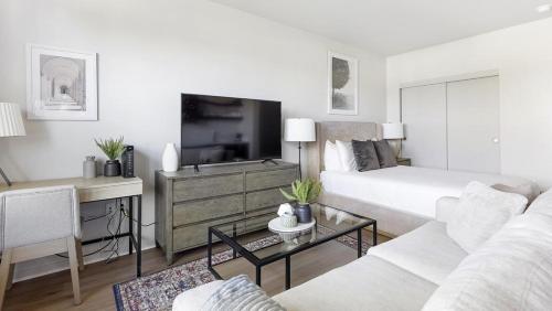 a white living room with a bed and a tv at Landing Modern Apartment with Amazing Amenities (ID1357X457) in Portland