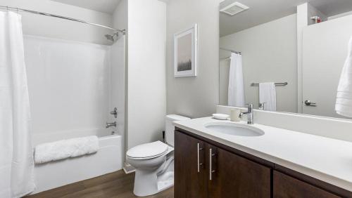 La salle de bains blanche est pourvue de toilettes et d'un lavabo. dans l'établissement Landing Modern Apartment with Amazing Amenities (ID1357X457), à Portland