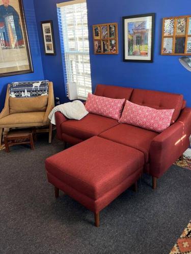 a living room with a red couch and a chair at Cozy and Peaceful Tiny House on a 100-acre Farm in Lewisville