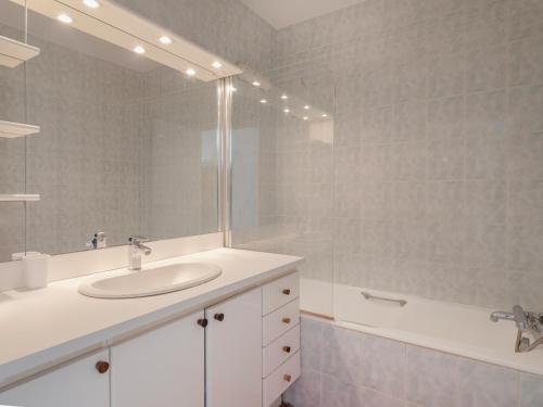 une salle de bain avec un lavabo, un miroir et une baignoire dans l'établissement Eiffel Tower Loft residence, à Paris
