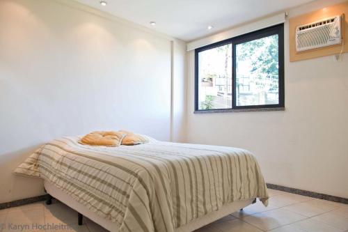 1 dormitorio con 1 cama con manta y ventana en Apartamento Porto Real Angra Dos Reis, en Mangaratiba