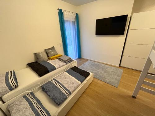 a bedroom with two bunk beds and a flat screen tv at Casa Tara in Döbriach