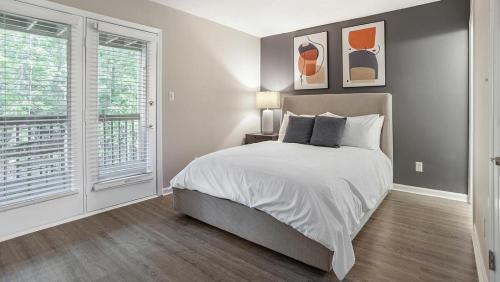 um quarto com uma cama e uma grande janela em Landing Modern Apartment with Amazing Amenities (ID1204X607) em Charlotte