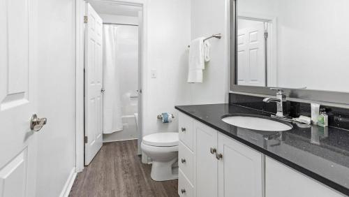 uma casa de banho branca com um WC e um lavatório em Landing Modern Apartment with Amazing Amenities (ID1204X607) em Charlotte