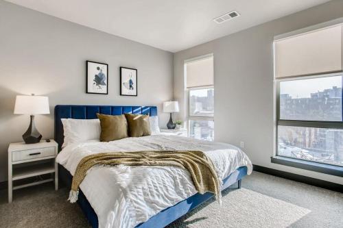 sypialnia z niebieskim łóżkiem i 2 oknami w obiekcie Landing Modern Apartment with Amazing Amenities (ID1963) w mieście Denver
