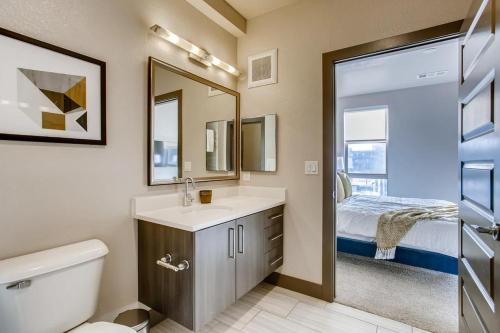 łazienka z umywalką, lustrem i łóżkiem w obiekcie Landing Modern Apartment with Amazing Amenities (ID1963) w mieście Denver