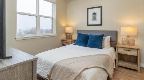 - une chambre avec un lit doté d'oreillers bleus et d'une fenêtre dans l'établissement Landing Modern Apartment with Amazing Amenities (ID2709X55), à Salt Lake City