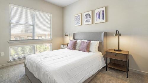 sypialnia z dużym białym łóżkiem i 2 oknami w obiekcie Landing Modern Apartment with Amazing Amenities (ID8635X10) w mieście Irving