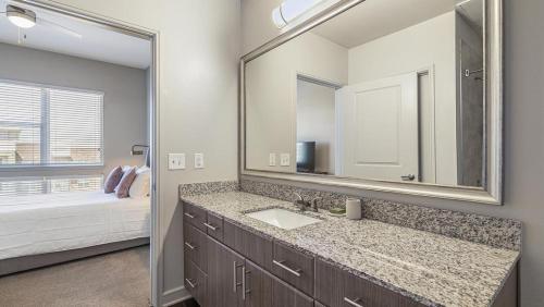 baño con lavabo y espejo grande en Landing Modern Apartment with Amazing Amenities (ID8635X10) en Irving