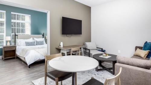 ein Wohnzimmer mit einem Bett und einem Tisch in der Unterkunft Landing Modern Apartment with Amazing Amenities (ID6308X34) in Columbus