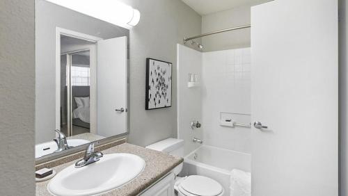 uma casa de banho branca com um lavatório e um WC em Landing Modern Apartment with Amazing Amenities (ID4301X28) em Las Vegas