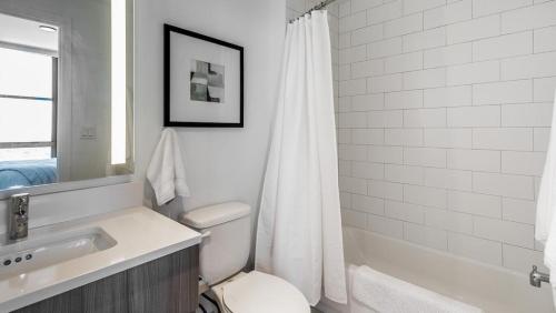 Landing Modern Apartment with Amazing Amenities (ID870) في فورت لاودردال: حمام مع حوض ومرحاض وحوض استحمام